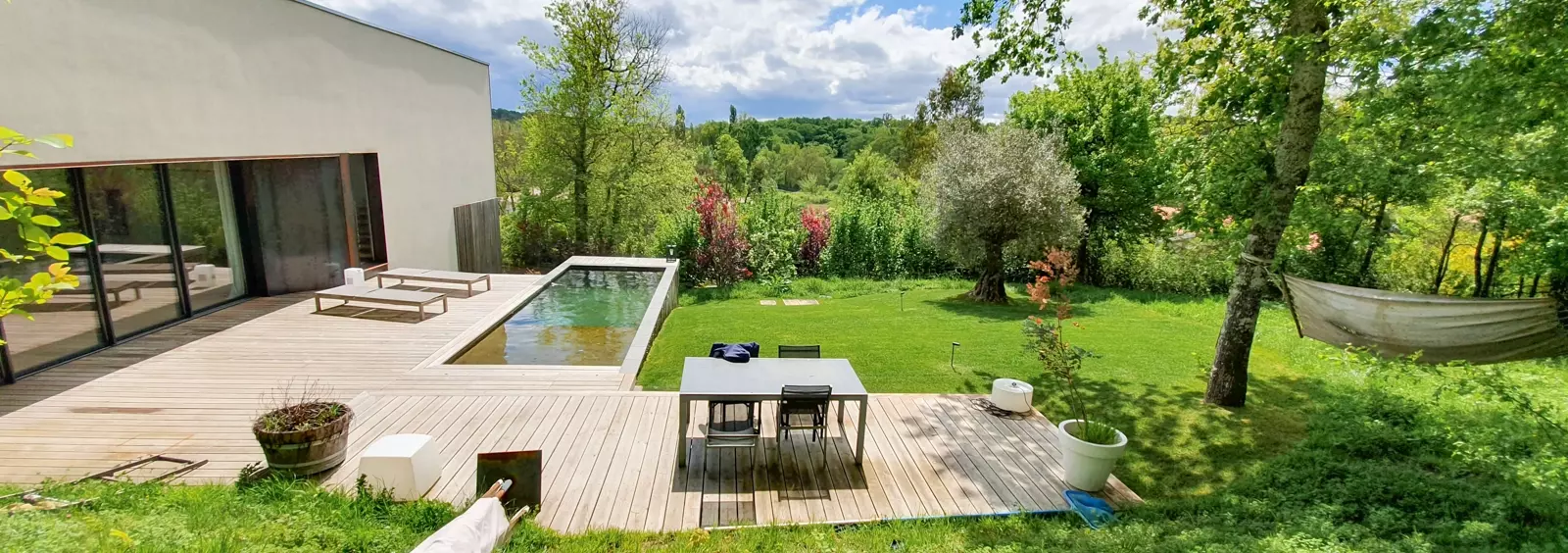 Aménagement de jardin avec terrasse en bois autour d'une piscine, pose de gazon en plaque, plantation d'arbres et d'arbustes