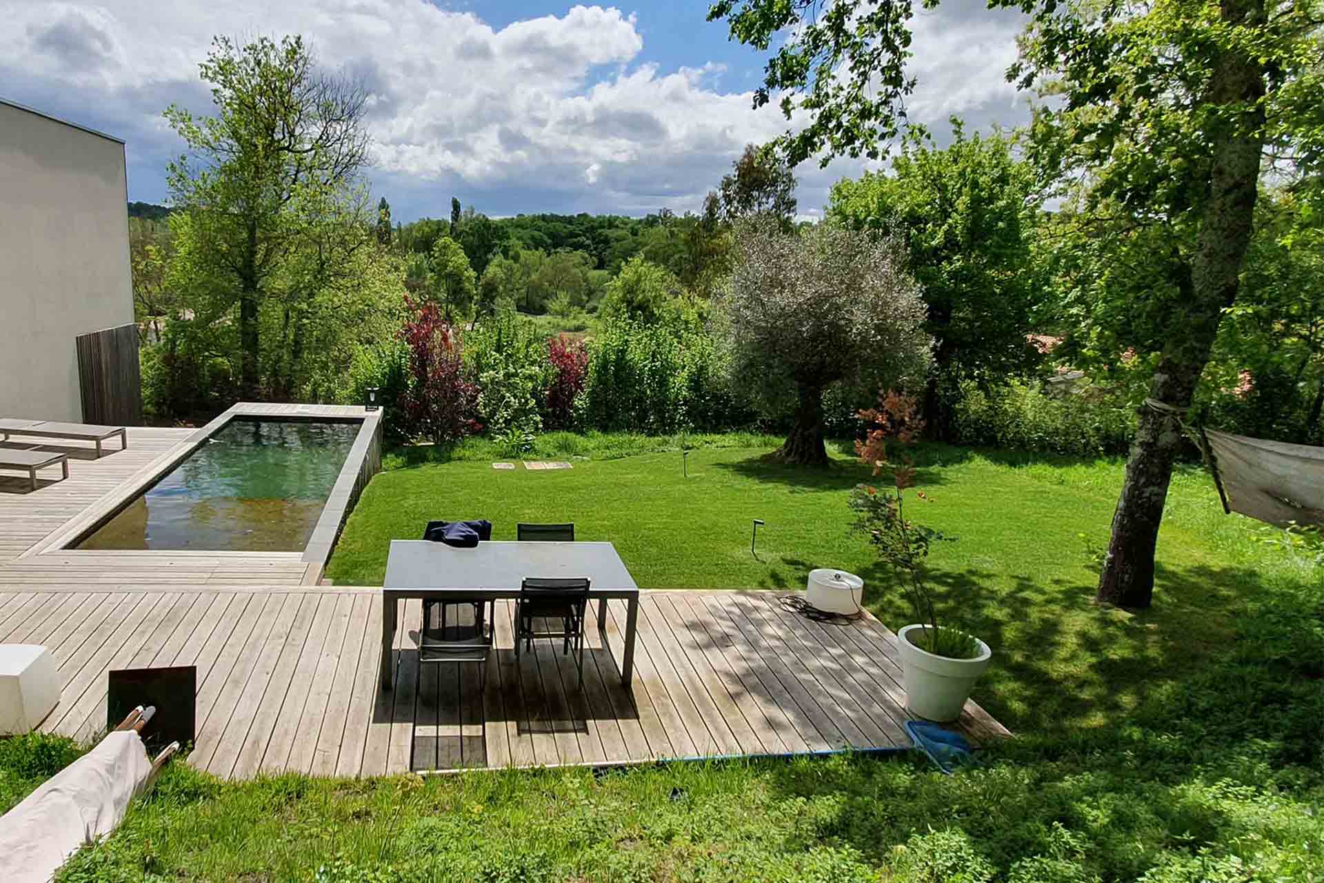 Exemple de design de jardin avec une terrasse, du gazon, des plantations et un coin détente