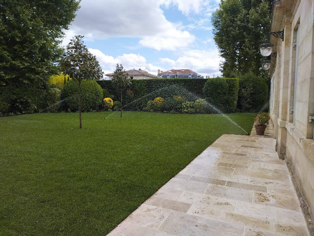 Aménagement d'un jardin avec plantation d'arbres, pose de gazon en plaque et arrosage automatique intégré