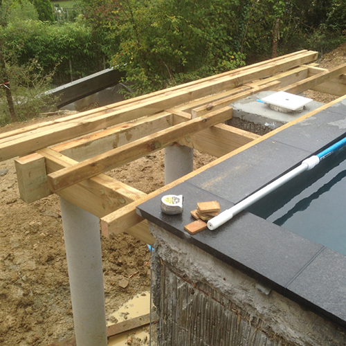 Photo d'une terrasse en bois surélevée en bordure de piscine