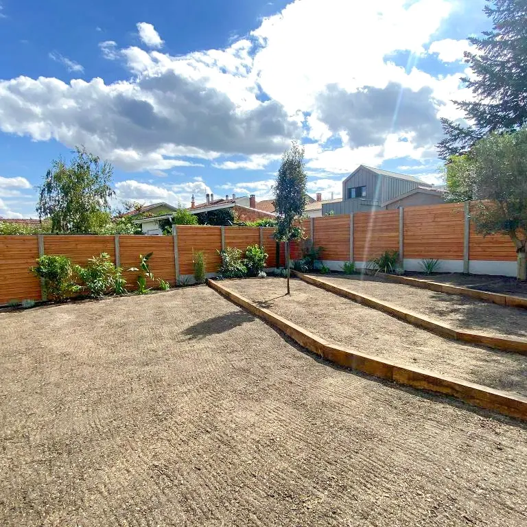 Aménagement paysager d'un jardin avec la mise en place de murets de soutènement et la plantation de végétaux