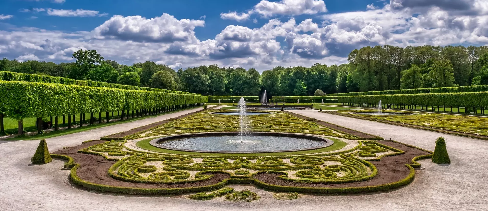 Photo du jardin du chateau de Versailles avec ses fontaines et plantations