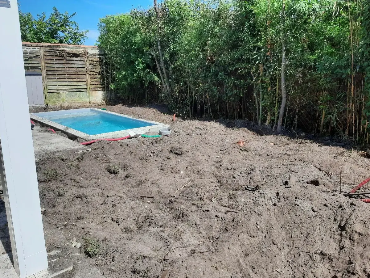 Photo du jardin avec l'aménagement de celui-ci, on peut y voir la piscine et la terre décompactée.