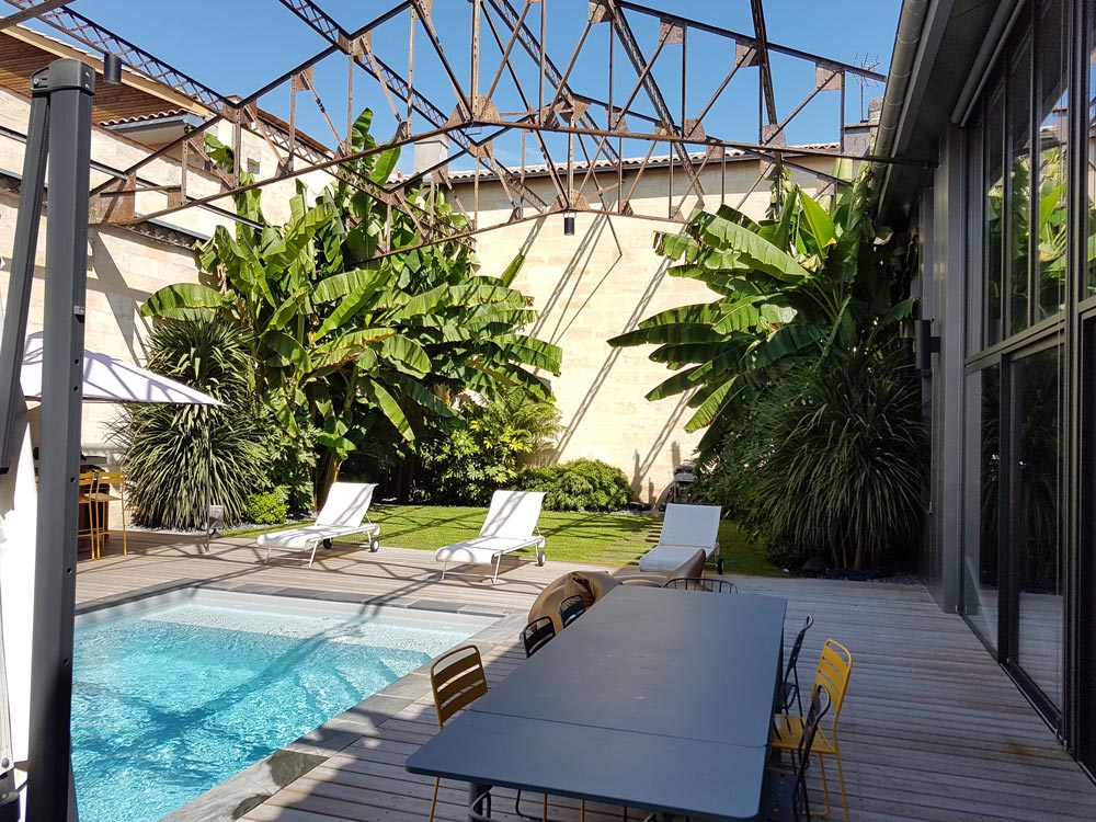 Photo d'un jardin avec piscine et des plantations style jardin exotique à Eysines 