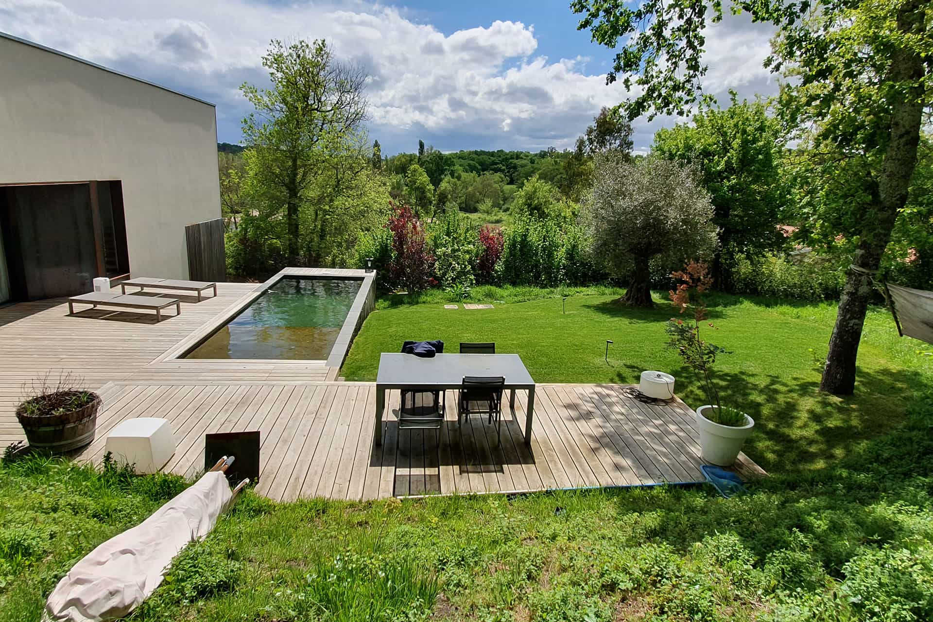 Photo d'un jardin aménagé avec piscine, terrasse et massifs