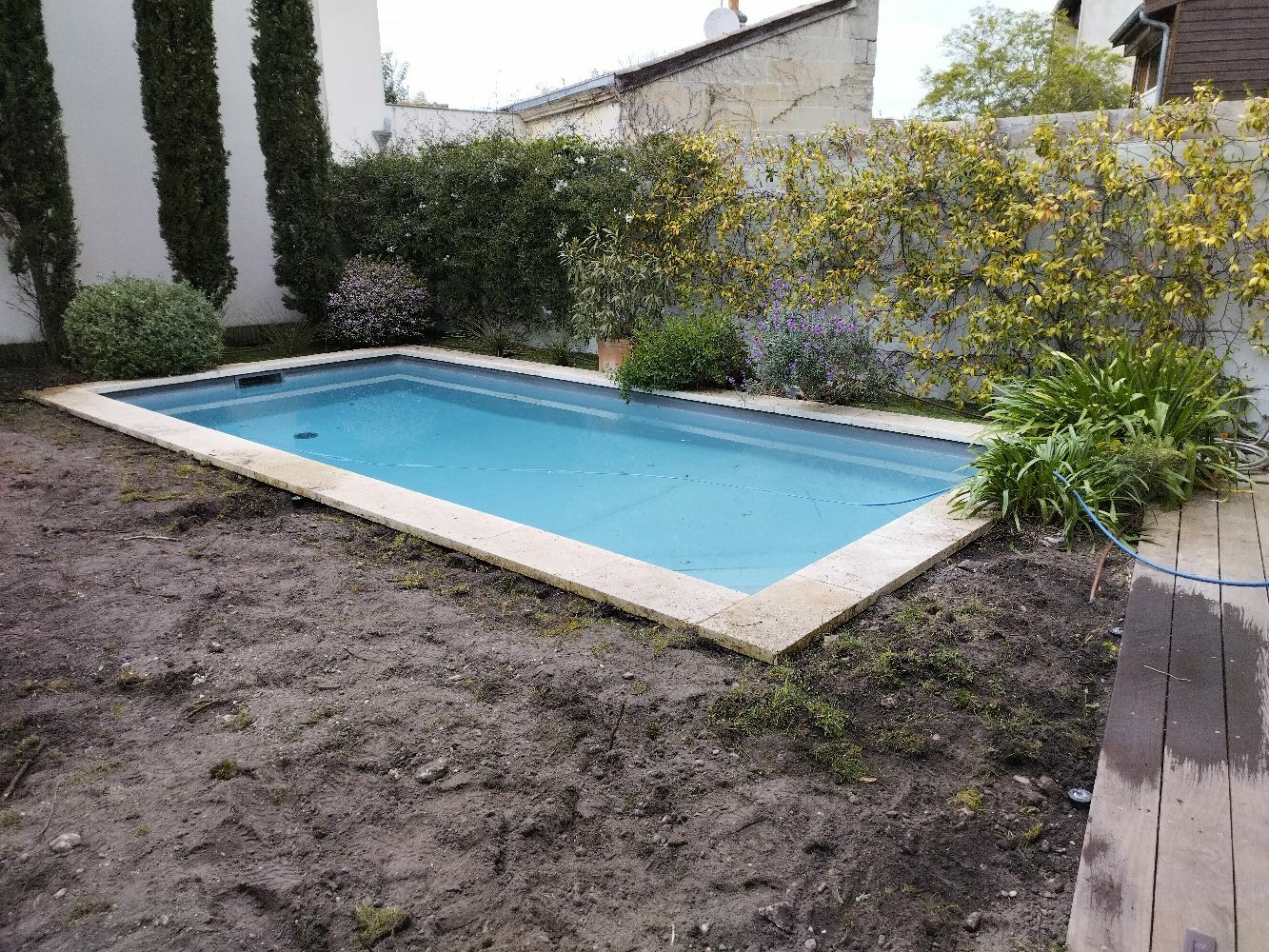 Aménagement d'extérieur avec la pose d'un gazon en plaque autour de la piscine